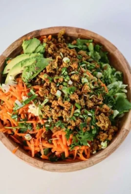 Healthy egg roll salad served in a bowl with colorful vegetables and dressing.