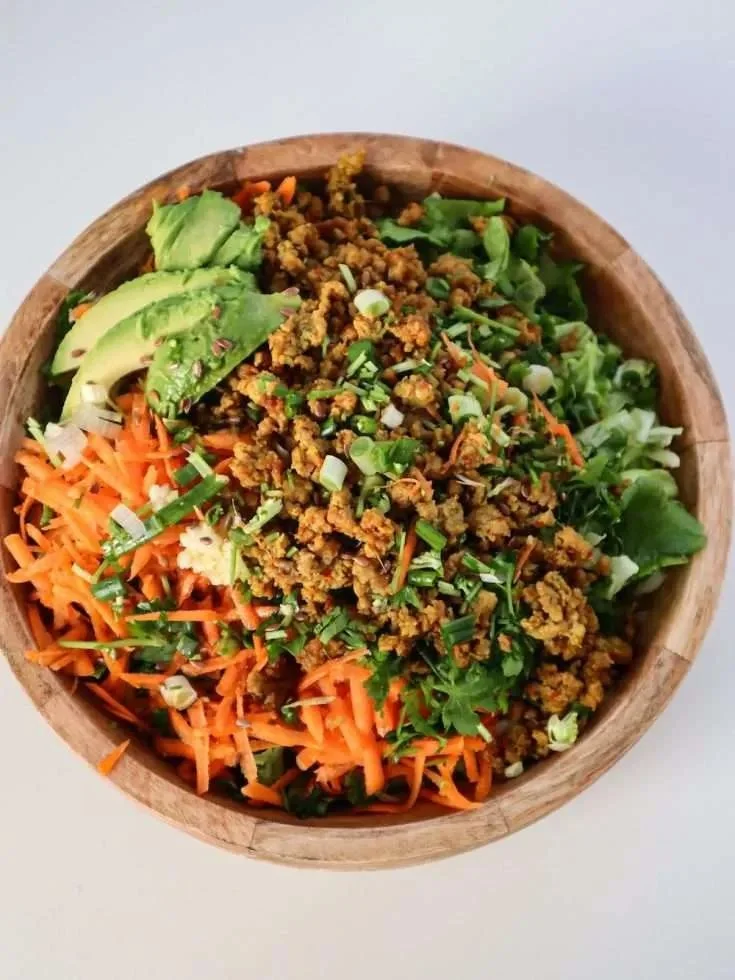 Healthy egg roll salad served in a bowl with colorful vegetables and dressing.