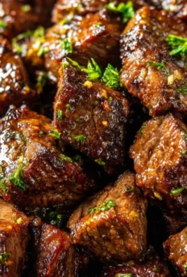 Plate of delicious garlic butter steak bites garnished with herbs