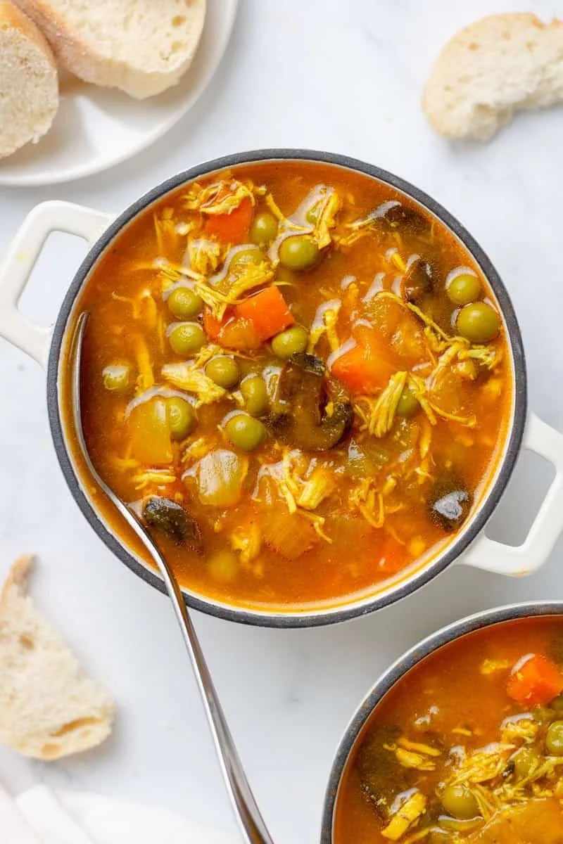 Bowl of healthy homemade chicken soup with colorful vegetables and herbs