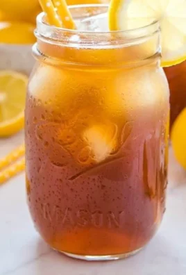 A refreshing glass of healthy homemade iced tea with lemon and mint.