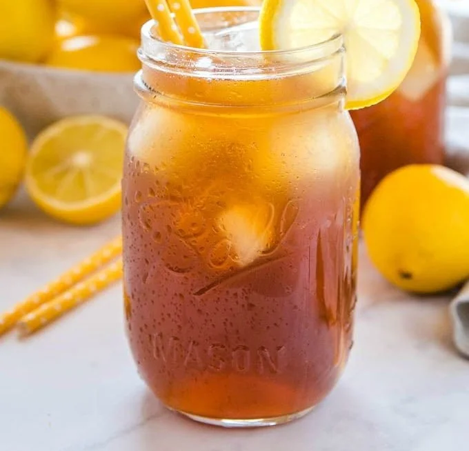 A refreshing glass of healthy homemade iced tea with lemon and mint.