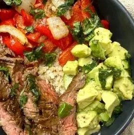 Delicious high protein steak fajita bowl with colorful vegetables and spices