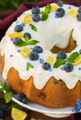 Lemon Blueberry Bundt Cake topped with Cream Cheese Icing on a dessert table.