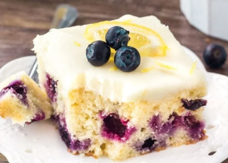 Lemon Blueberry Cake with fresh blueberries and lemon slices on a white plate