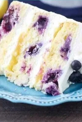 Slice of moist Lemon Blueberry Cake topped with fresh blueberries and lemon zest