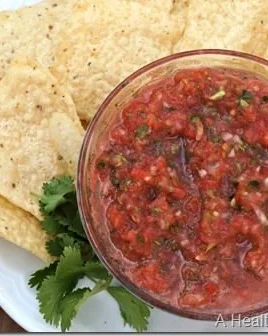 Bowl of perfect garden fresh salsa made with ripe tomatoes and herbs.