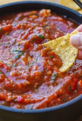 Bowl of homemade roasted tomato salsa with fresh herbs and spices