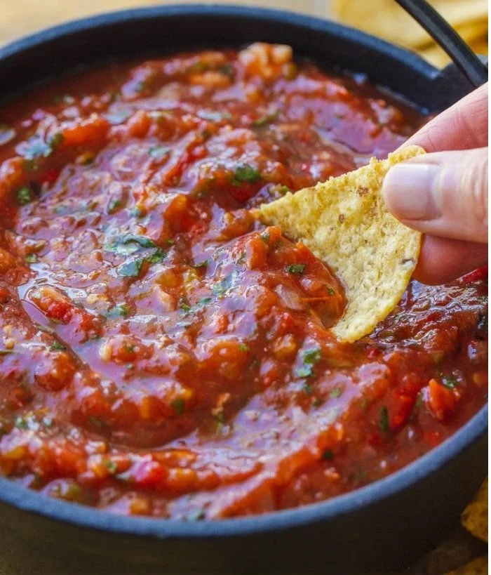 Bowl of homemade roasted tomato salsa with fresh herbs and spices