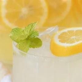Glass of refreshing mint lemonade with lemon slices and mint leaves