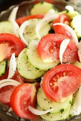 A fresh tomato, cucumber, and onion salad in a bowl, showcasing vibrant colors and healthy ingredients.