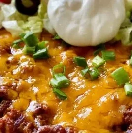 Delicious Walking Taco Casserole topped with cheese and crunchy toppings